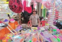 होली के त्योहार पर लाल गुलाबी रंग मे रंगा अखण्डनगर चौक दुकानो को सजाकर बैठे लोग